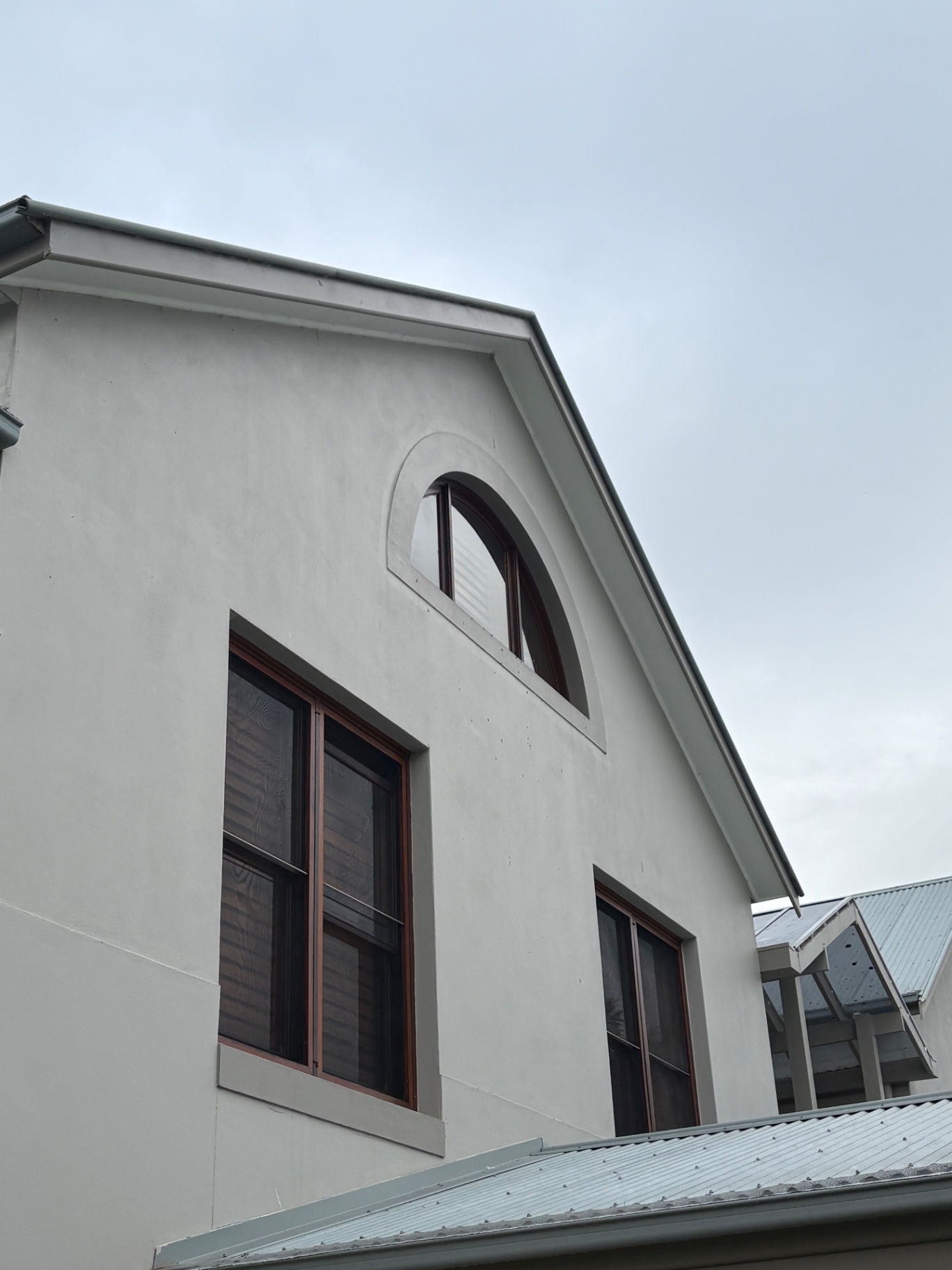 Gable end with arched highlight window and timber double-hung windows