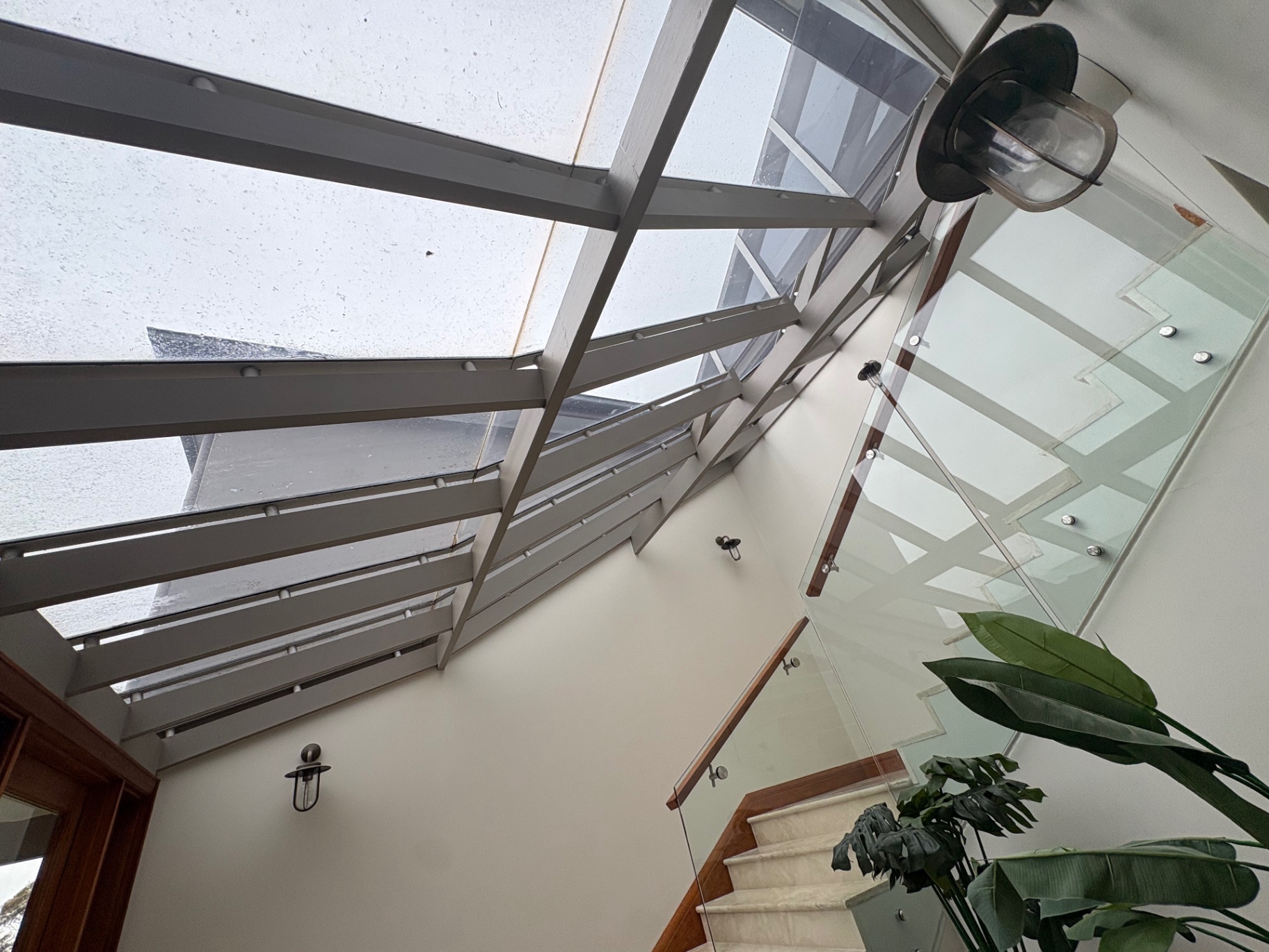Glass-roofed entry with glass balustrade over the stair